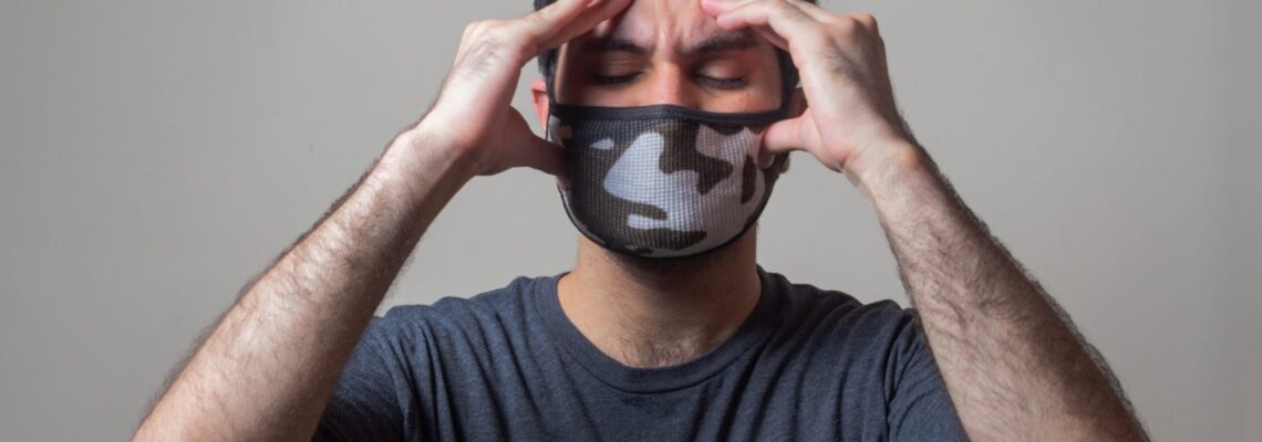 Man with mask holding head